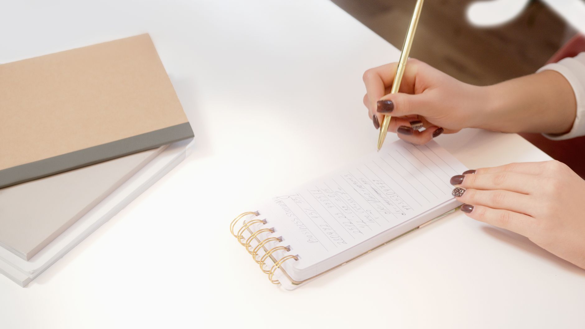 Mãos escrevendo em um caderno